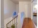 Upstairs hallway featuring a wooden floor, railing, and a small window for natural light at 2142 E Turney Ave # 4, Phoenix, AZ 85016