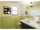 Bright bathroom with green tile, retro-style fixtures, modern sink, and decorative art, creating a clean space at 2201 N Central Ave # 2A, Phoenix, AZ 85004