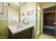 Updated bathroom with green tile, modern sink, sleek vanity, and decorative art, offering a refreshing feel at 2201 N Central Ave # 2A, Phoenix, AZ 85004