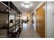 Long hallway view with open shelving, polished floors, and a view to the living area at 2201 N Central Ave # 2A, Phoenix, AZ 85004