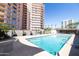 Well-maintained community swimming pool with lounge chairs and high rise building at 2201 N Central Ave # 2A, Phoenix, AZ 85004