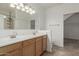 Bright bathroom with dual sinks, wood cabinets, large mirror and tiled floors at 22905 N 19Th Way, Phoenix, AZ 85024