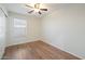 Minimalist bedroom featuring a ceiling fan, hardwood floors, and a window for natural light at 2472 W Hawks Eye Ave, Apache Junction, AZ 85120