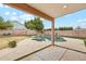 Covered patio with a pool and spa featuring a rock waterfall, surrounded by a block fence and green landscaping at 2472 W Hawks Eye Ave, Apache Junction, AZ 85120