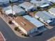 An aerial view shows a house nestled within a community, with a mix of gray and brown rooftops at 2550 E Ellsworth Rd # 791, Mesa, AZ 85209