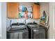 Well-lit laundry room with upper cabinets and side-by-side stainless steel washer and dryer at 2550 E Ellsworth Rd # 791, Mesa, AZ 85209