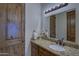 Bathroom vanity featuring granite counters, wood cabinets, and decorative lighting at 2729 W Dolores Rd, Phoenix, AZ 85086