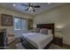 Bedroom with dark wood furniture, ceiling fan, and a window with views at 2729 W Dolores Rd, Phoenix, AZ 85086