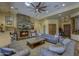 Cozy living room features a stone fireplace, ceiling fan, wood floors, and comfortable seating at 2729 W Dolores Rd, Phoenix, AZ 85086