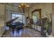 Elegant room featuring a grand piano and a decorative chandelier at 2729 W Dolores Rd, Phoenix, AZ 85086