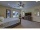 Main bedroom with plush carpeting, a ceiling fan, large window, and ample space for seating and entertainment at 2729 W Dolores Rd, Phoenix, AZ 85086