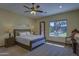 Comfortable main bedroom with soft carpet, ceiling fan, large window, and an exterior door at 2729 W Dolores Rd, Phoenix, AZ 85086