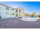 Backyard view of the house with a pool and a patio, desert landscaping, and an upstairs balcony at 30402 W Vale Dr, Buckeye, AZ 85396