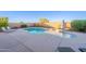 Large free form pool in a walled backyard with desert landscaping and an umbrella for shade at 30402 W Vale Dr, Buckeye, AZ 85396