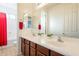 Bright bathroom with double sinks, wood cabinets, and red shower curtain at 30402 W Vale Dr, Buckeye, AZ 85396