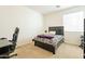 Simple bedroom with a dark-colored bed frame, neutral walls and a carpeted floor at 30402 W Vale Dr, Buckeye, AZ 85396