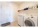 Functional laundry room equipped with modern washing machine, dryer and built-in shelving at 30402 W Vale Dr, Buckeye, AZ 85396