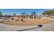 A modern playground with various climbing structures and riding toys on a mulch base at 30402 W Vale Dr, Buckeye, AZ 85396