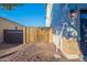 View of a side yard with desert landscaping and a wooden gate at 30402 W Vale Dr, Buckeye, AZ 85396