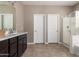 Bright bathroom featuring double doors, neutral walls, and a glass shower at 30876 W Verde Ln, Buckeye, AZ 85396