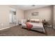 Comfortable bedroom features soft carpet, neutral walls, and an en-suite bathroom at 30876 W Verde Ln, Buckeye, AZ 85396