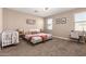 Well-lit bedroom with neutral tones, featuring a crib, desk, and carpeted floors at 30876 W Verde Ln, Buckeye, AZ 85396