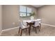 Bright dining area with a modern table, stylish chairs, and a large window providing natural light and outdoor views at 30876 W Verde Ln, Buckeye, AZ 85396