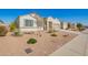 Well-maintained single story home with a two-car garage and desert landscaping, a sidewalk, and street views at 30876 W Verde Ln, Buckeye, AZ 85396