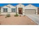 Charming single-story home with desert landscaping, two-car garage, and a welcoming red front door at 30876 W Verde Ln, Buckeye, AZ 85396