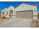 Single-story home with desert landscaping, a two-car garage, and a concrete driveway and with street views at 30876 W Verde Ln, Buckeye, AZ 85396