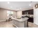 Bright, open-concept kitchen with stainless appliances and granite island extending to a dining nook at 30876 W Verde Ln, Buckeye, AZ 85396