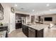 Open kitchen featuring stainless steel appliances and a granite island, adjacent to the living room at 30876 W Verde Ln, Buckeye, AZ 85396