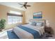 Staged main bedroom features a ceiling fan, large window and a king bed with blue accents at 309 E Mountain Sky Ave, Phoenix, AZ 85048