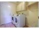 Bright laundry room with washer, dryer, cabinets, and shelving at 309 E Mountain Sky Ave, Phoenix, AZ 85048