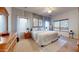 Spacious main bedroom with large windows, a ceiling fan, gray accent wall, and a wooden dresser and nightstand at 33732 N Sandstone Dr, San Tan Valley, AZ 85143