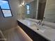 Bright bathroom featuring double sinks, modern lighting, and an oversized mirror at 37931 N 31St Ave, Phoenix, AZ 85086