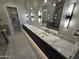 Modern bathroom with dual sinks, quartz countertop, large mirrors and stylish lighting fixtures in a newly built home at 37931 N 31St Ave, Phoenix, AZ 85086