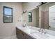 Bright bathroom featuring double sinks, modern lighting, and an oversized mirror at 37931 N 31St Ave, Phoenix, AZ 85086