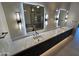 Modern bathroom featuring dual sinks, quartz countertop, large mirrors with stylish lighting fixtures and walk-in shower at 37931 N 31St Ave, Phoenix, AZ 85086