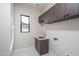 Laundry room featuring wooden cabinets, a sink, and a window at 37931 N 31St Ave, Phoenix, AZ 85086