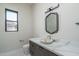 Modern powder room with a unique bowl sink and a geometric mirror at 37931 N 31St Ave, Phoenix, AZ 85086