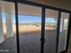 View from inside through a modern sliding glass door and the patio and mountain views beyond at 37931 N 31St Ave, Phoenix, AZ 85086