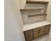 Close-up of entryway shelving above built-in cabinets with quartz countertops at 37937 N 31St Ave, Phoenix, AZ 85086