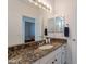 Bathroom vanity featuring granite countertops, a sink, and a large mirror with vanity lighting at 4266 E Cassia Ln, Gilbert, AZ 85298