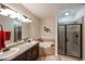 Bathroom featuring a tub, shower with a glass door, and a vanity with double sinks at 5350 E Deer Valley Dr # 1275, Phoenix, AZ 85054