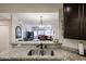 Open kitchen view to living room with granite counters, stainless steel sink and pendant lighting at 5350 E Deer Valley Dr # 1275, Phoenix, AZ 85054