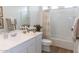 Modern bathroom with a shower over tub, white cabinets, dual basket storage, and wood-look flooring at 5912 S Daisy Patch Pl, Phoenix, AZ 85040