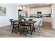 Bright dining area with modern lighting, and white cabinets, adjacent to a kitchen with stainless steel appliances at 5912 S Daisy Patch Pl, Phoenix, AZ 85040