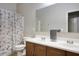 Bathroom featuring dual sinks, vanity, a toilet, and shower with curtain at 6109 S 30Th Dr, Phoenix, AZ 85041