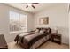 Comfortable bedroom featuring a striped bed, nightstand with lamp, and natural light from a window at 6589 E Casa De Leon Ln, Gold Canyon, AZ 85118